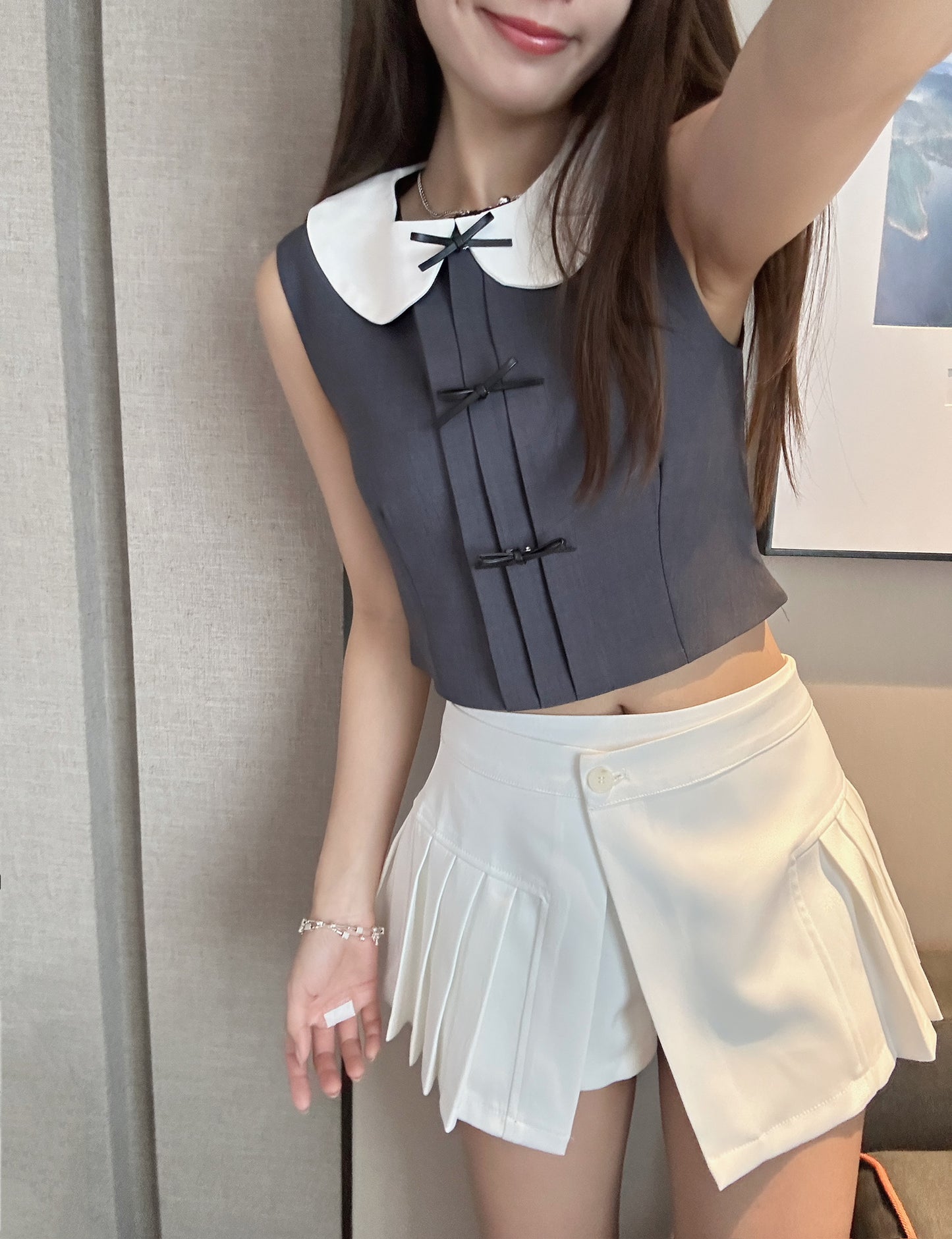 Sleeveless cropped vest top with leather ribbon pin